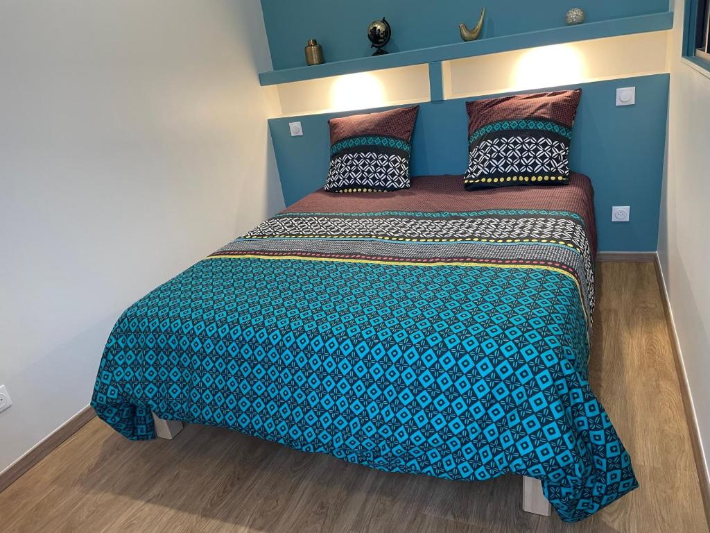 um quarto com uma cama com uma parede azul em Gite du Port em Dieppe