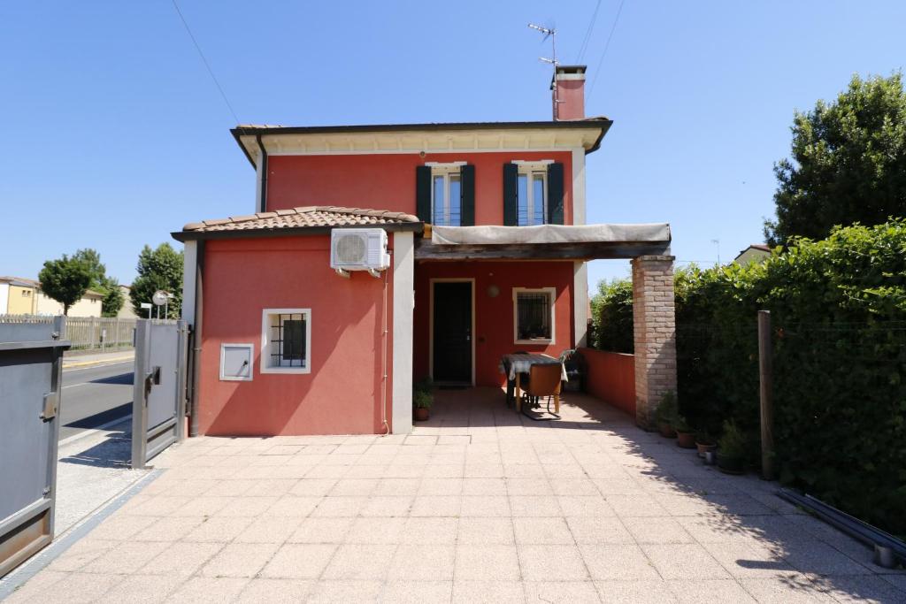 een rood huis op een straat met een oprit bij Donatella House in Piove di Sacco
