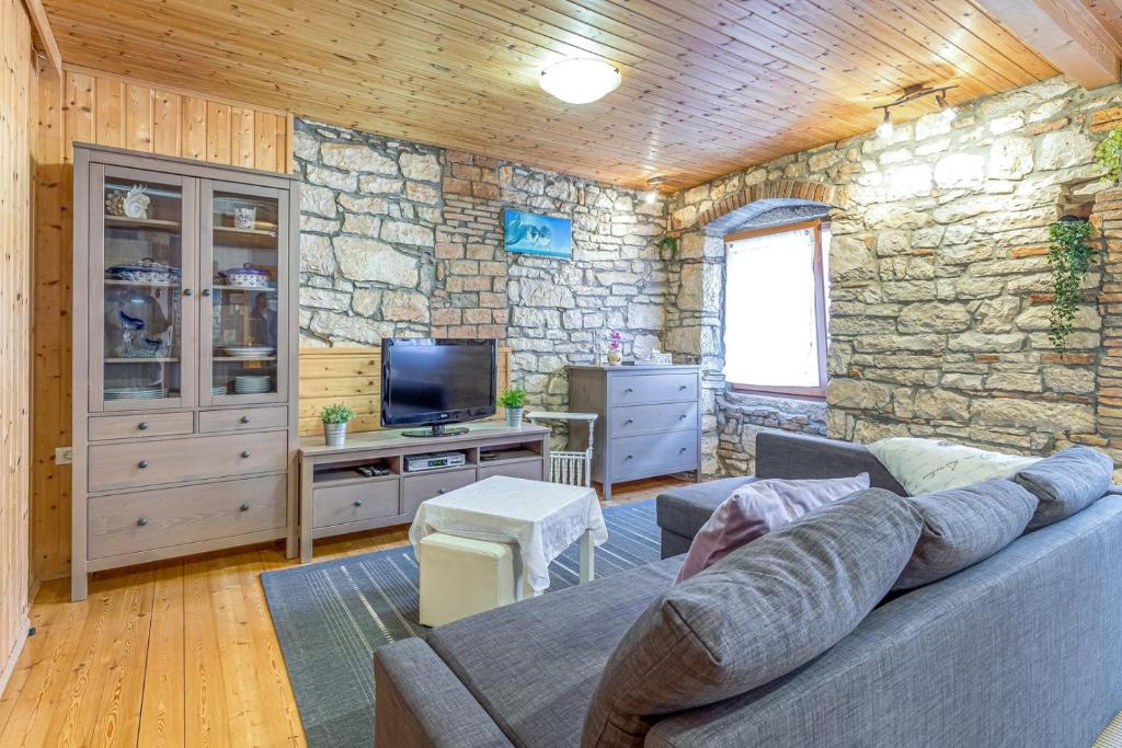 - un salon avec un canapé et un mur en pierre dans l'établissement Dino Carrera, à Rovinj