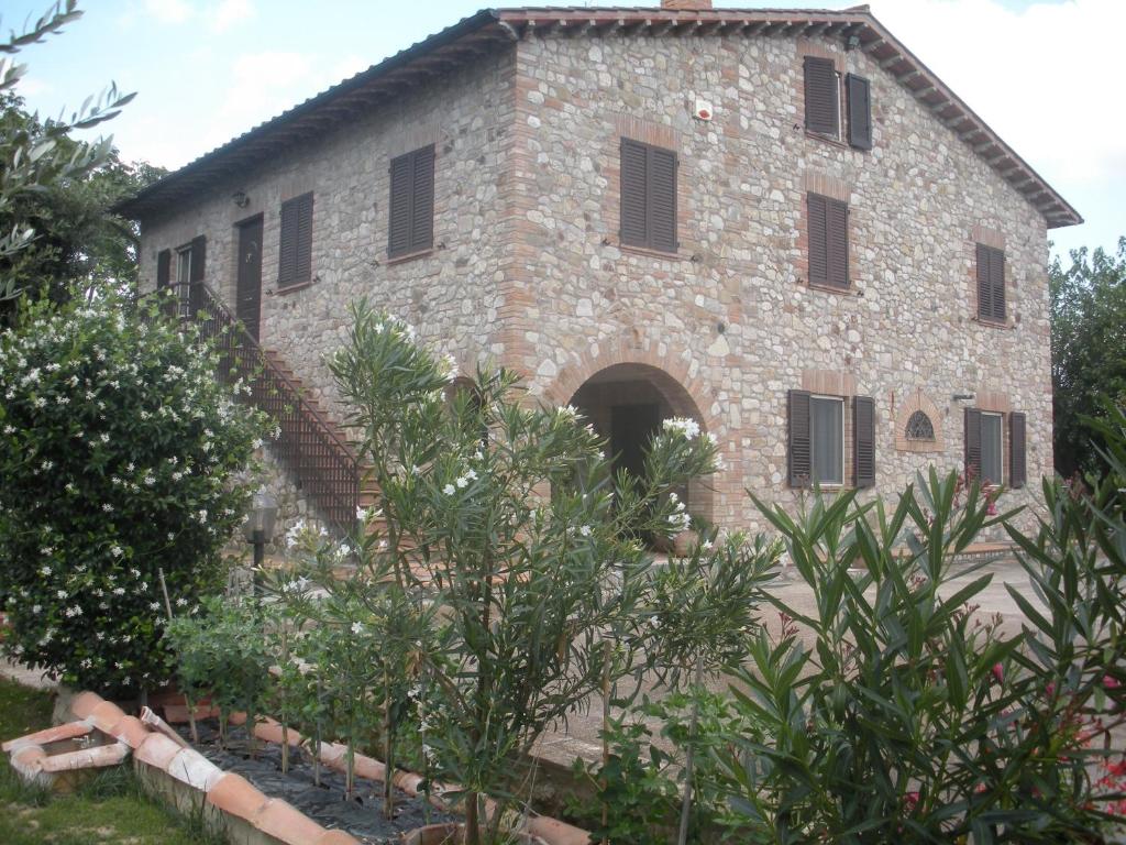un antico edificio in pietra con cortile e alberi di Ai Prati Vecchi a Marsciano