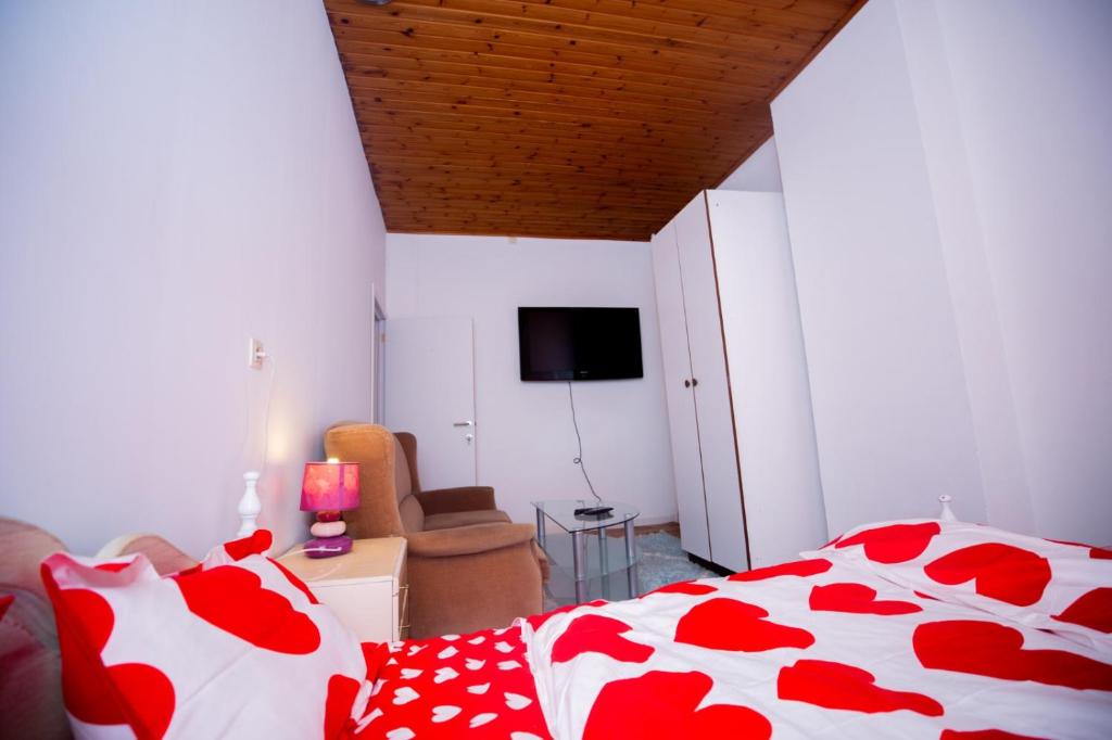 - une chambre dotée d'un lit avec des draps rouges et blancs dans l'établissement Agréable chambre sur liège avc parking et wifi gratuit, à Liège