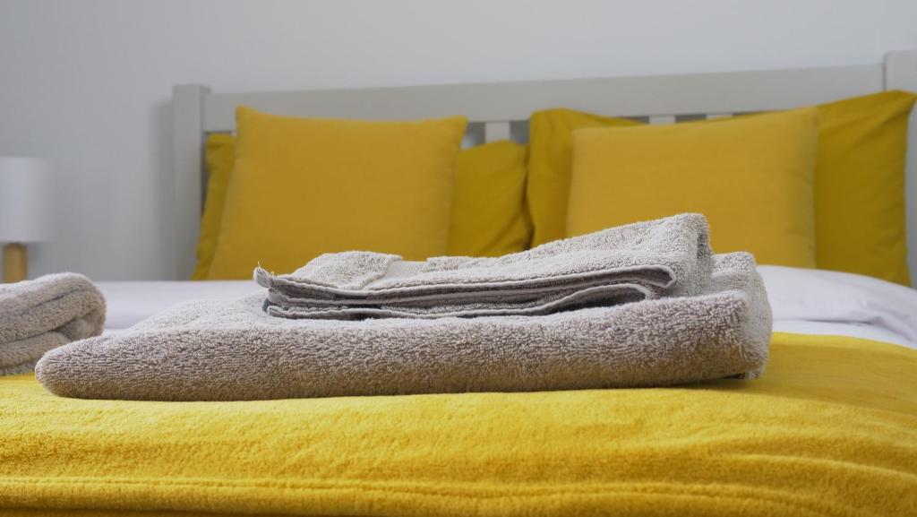 a pile of towels sitting on top of a bed at The Homestead House in Doncaster