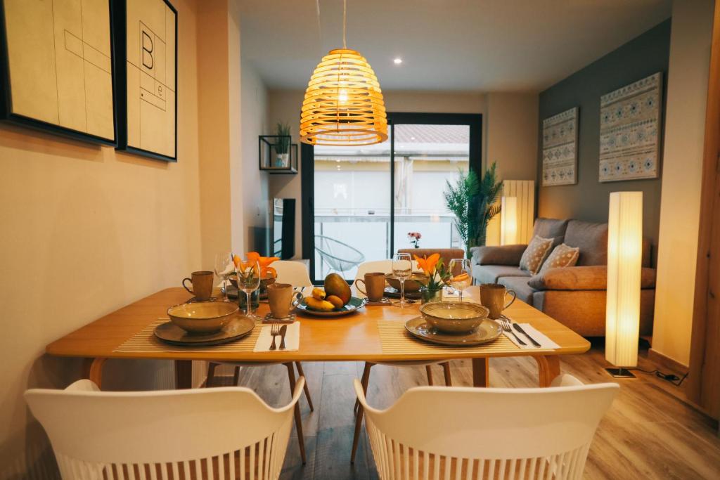 un comedor con mesa y sillas y una habitación con sofá en RCE Apartments Calella, brand new next to the beach. en Calella