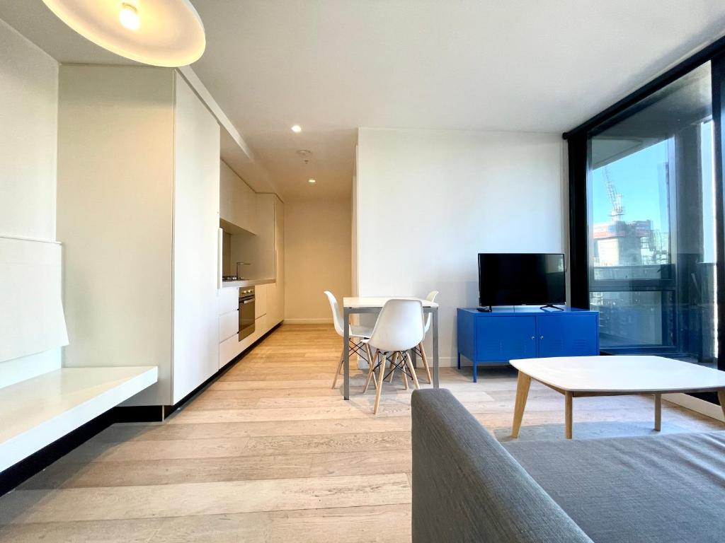 a living room with a kitchen and a table at Readyset Apartments at Empire in Melbourne