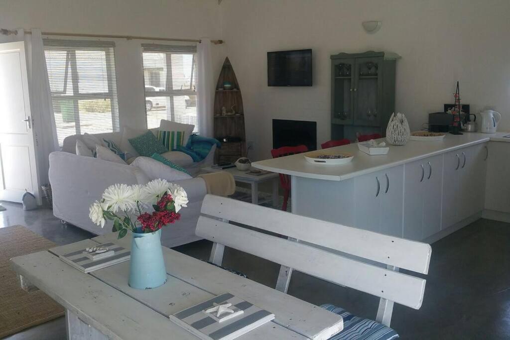 a living room with a vase of flowers on a table at Huis Maria in Golden Mile in Stompneusbaai