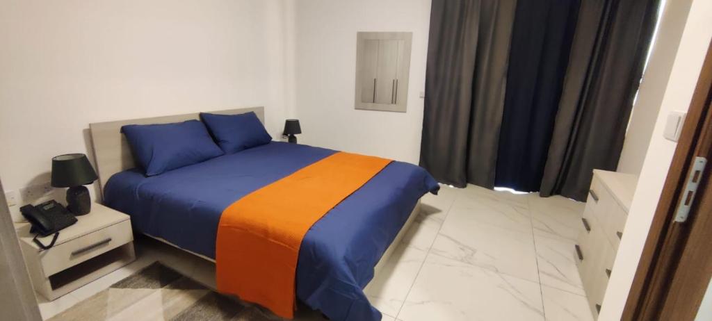 a bedroom with a bed with blue and orange at Blu-M Central in Qormi