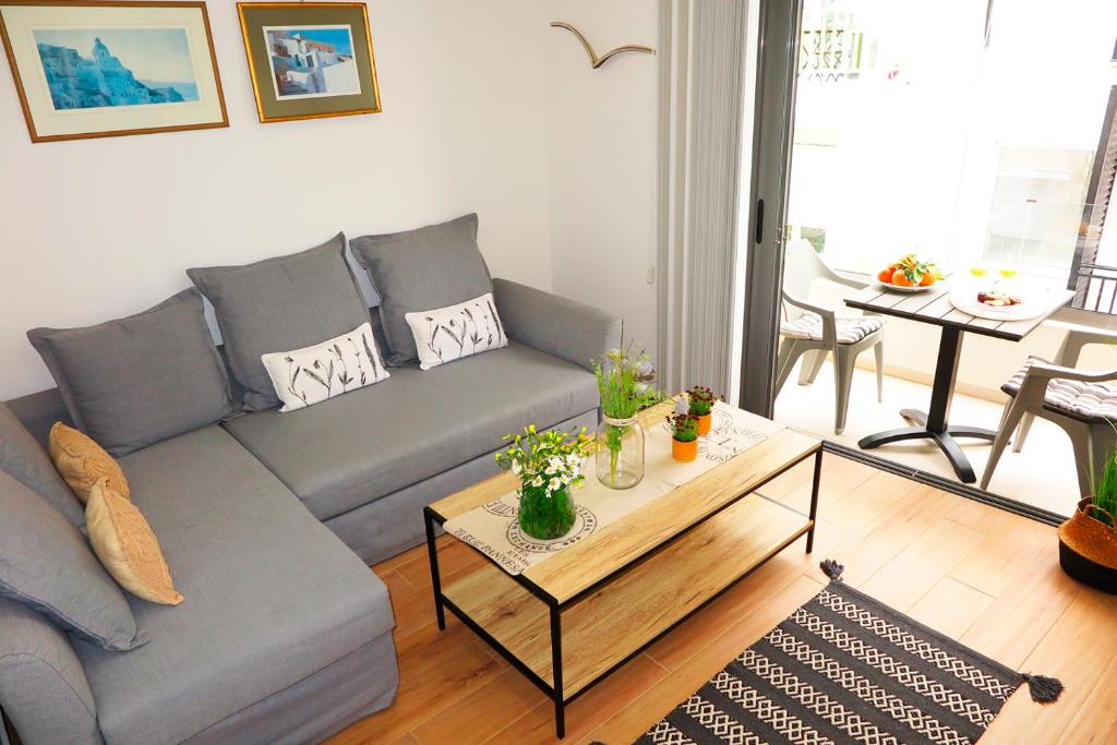uma sala de estar com um sofá e uma mesa de centro em Opus Suite em Ierápetra