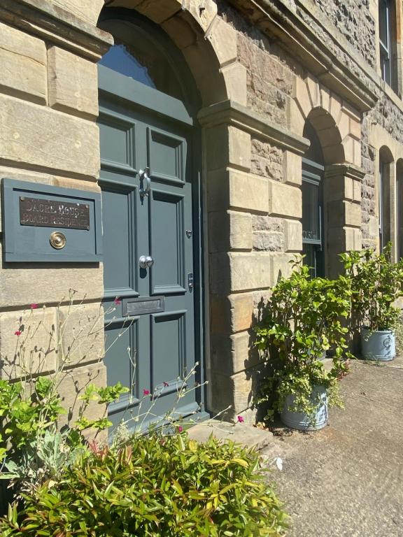 a blue door on the side of a building at Dacre House, Gilsland in Gilsland