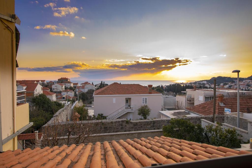 Una vista desde un tejado de una ciudad con la puesta de sol. en Apartments Kristić, en Dubrovnik