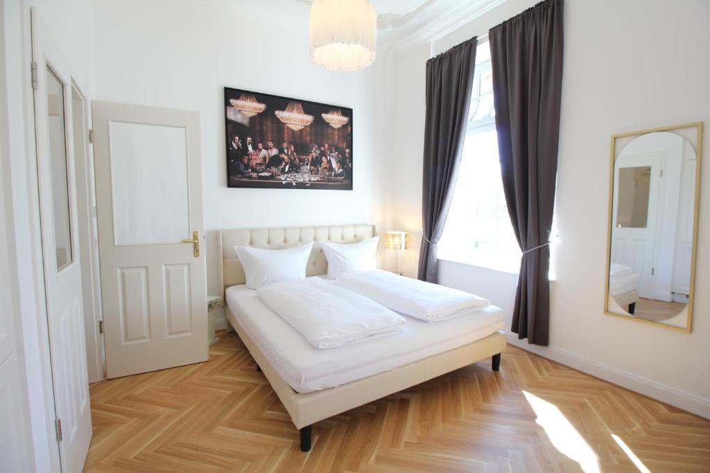 a bedroom with a white bed and a mirror at Zu Besuch im Palast - Perfekte Lage in Dresden