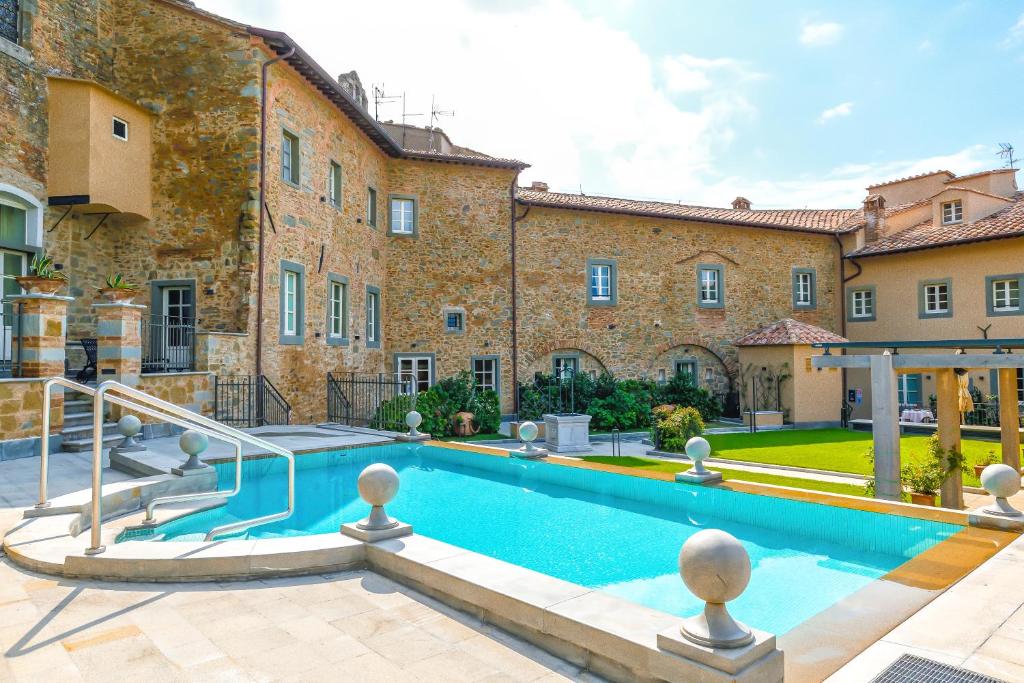 ein Grundstück mit einem Pool vor einem Gebäude in der Unterkunft Monastero Di Cortona Hotel & Spa in Cortona