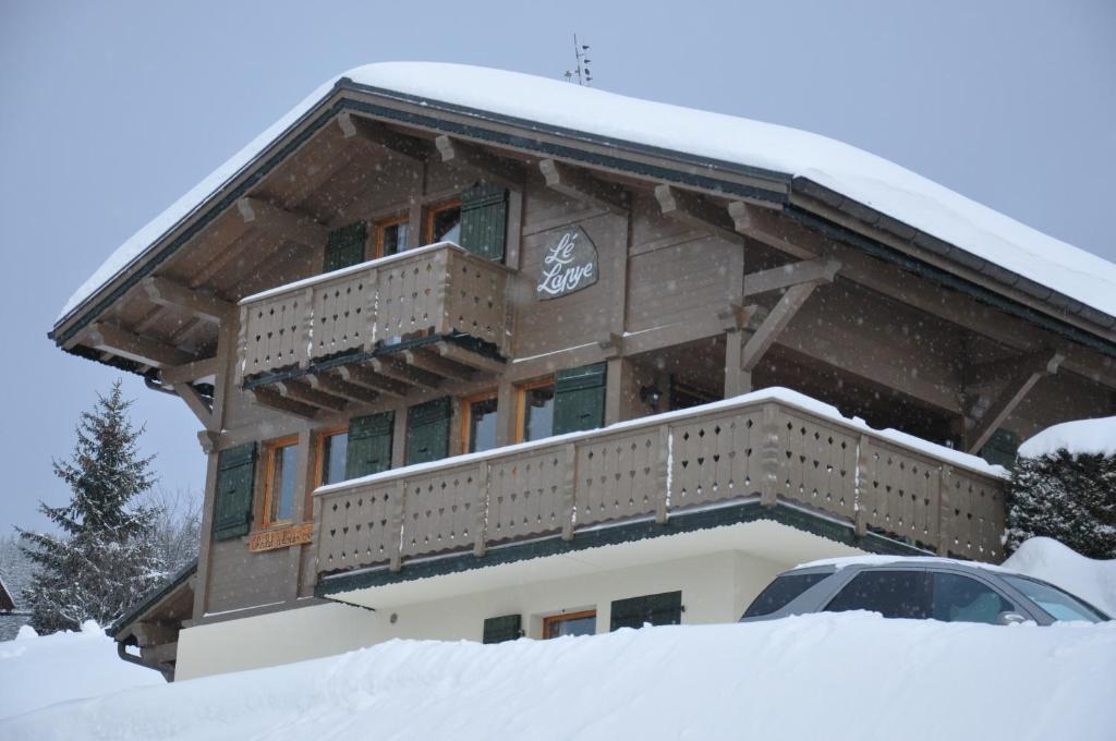 a house with a balcony in the snow at Chalet Le Lapye in Les Gets