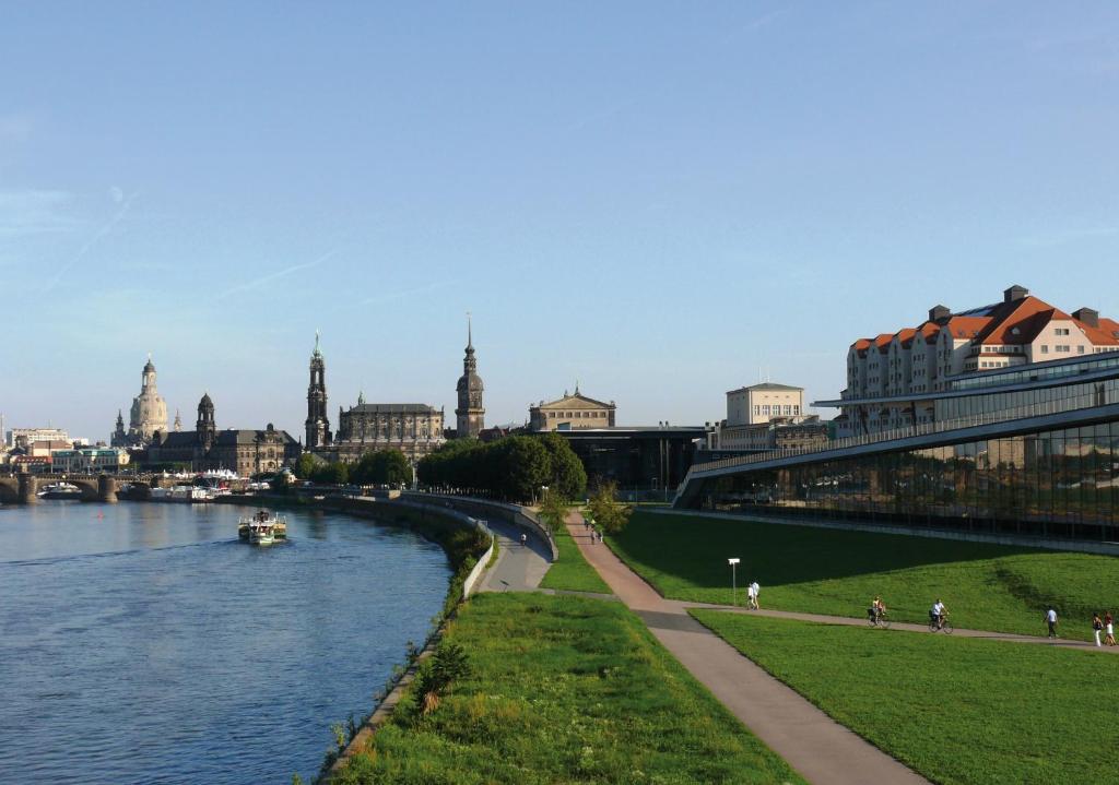 une vue sur une rivière avec une ville en arrière-plan dans l'établissement Maritim Hotel Dresden, à Dresde