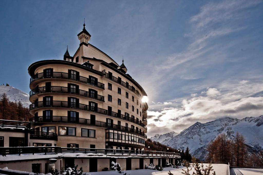 a large building with a clock tower on top of it at Principi di Piemonte Sestriere in Sestriere