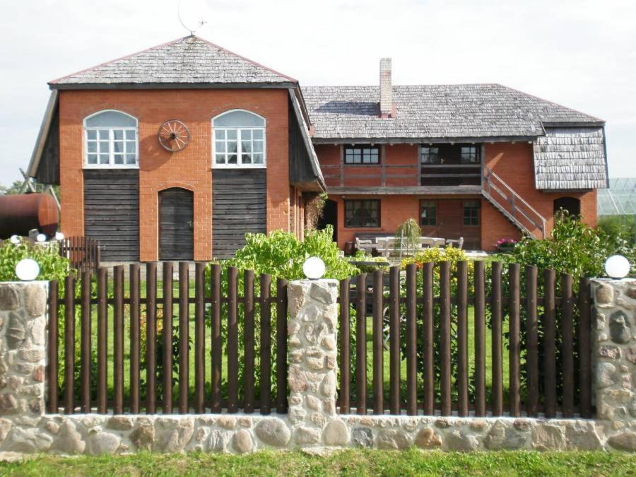 una valla de madera frente a una casa en Viesu nams Pūpoli en Dundaga