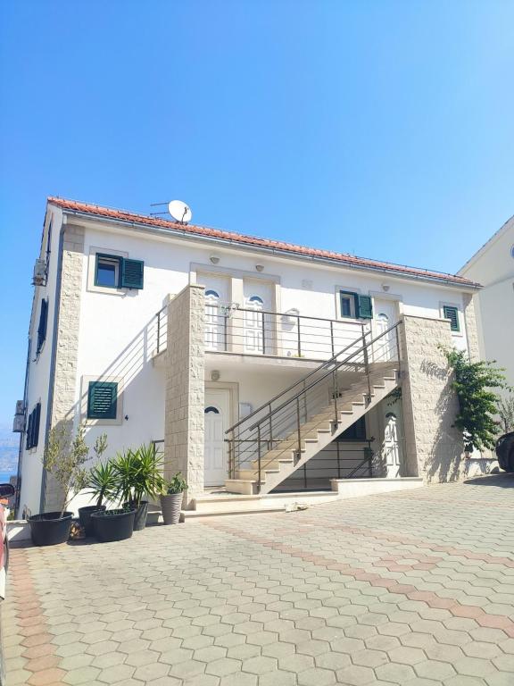 un grand bâtiment blanc avec un escalier. dans l'établissement Apartman Elephant, à Postira