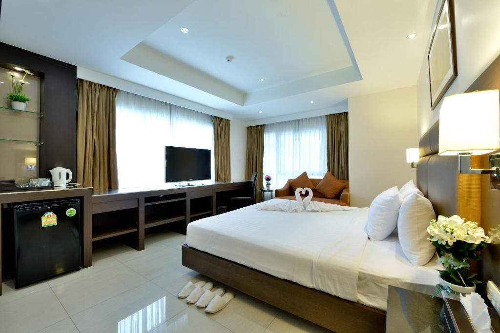 una camera con un grande letto e una televisione di The Prestige Nana a Bangkok