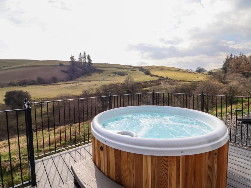 Un jacuzzi en una terraza con valla en The Sheep Shed, en Oswestry