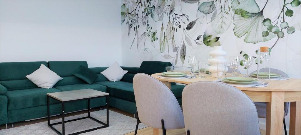 Apartament Botanika في سوبوت: غرفة معيشة مع أريكة خضراء وطاولة