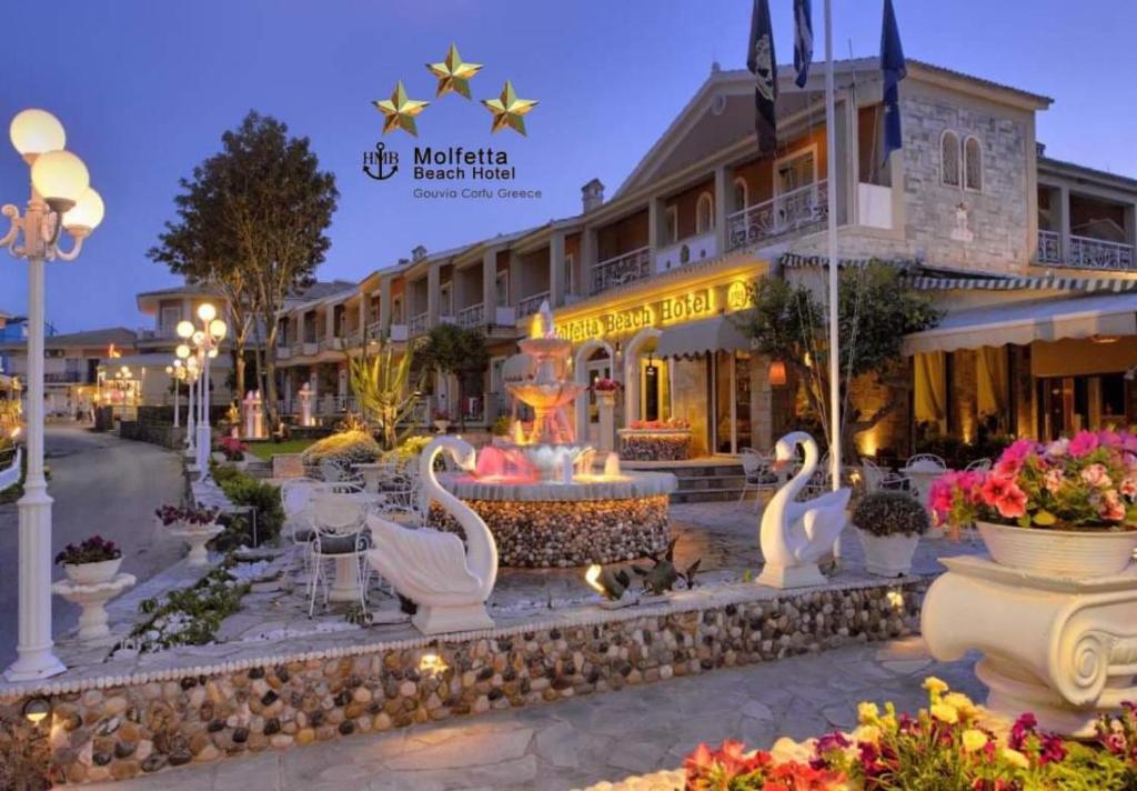 a resort with swans in front of a building at Molfetta Beach Hotel  in Gouvia