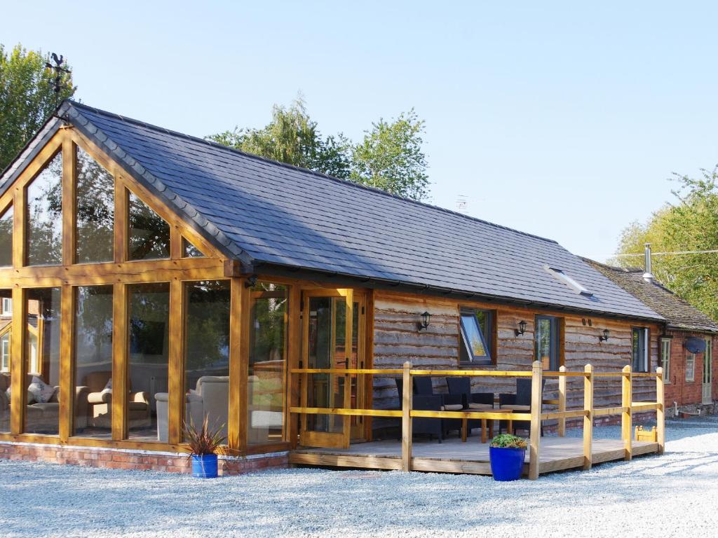 a large wooden cabin with a black roof at Haimwood Byetake in Llanymynech