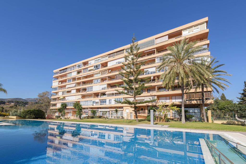 un hotel con piscina frente a un edificio en Estudio La Colina, en Torremolinos