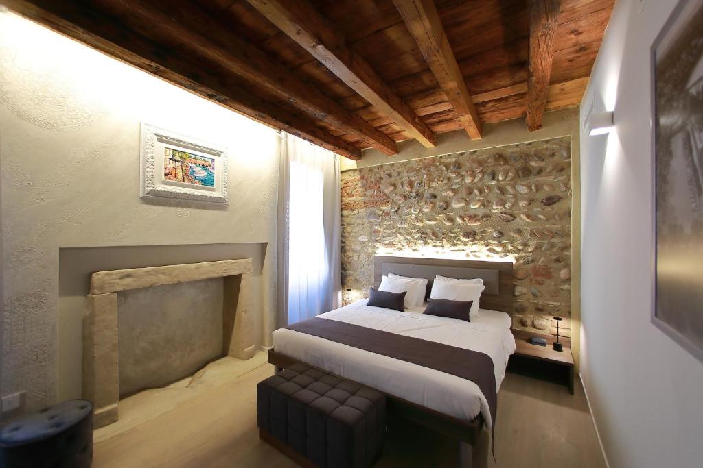 una camera con un grande letto e un camino di La Casa in Paese a Peschiera del Garda