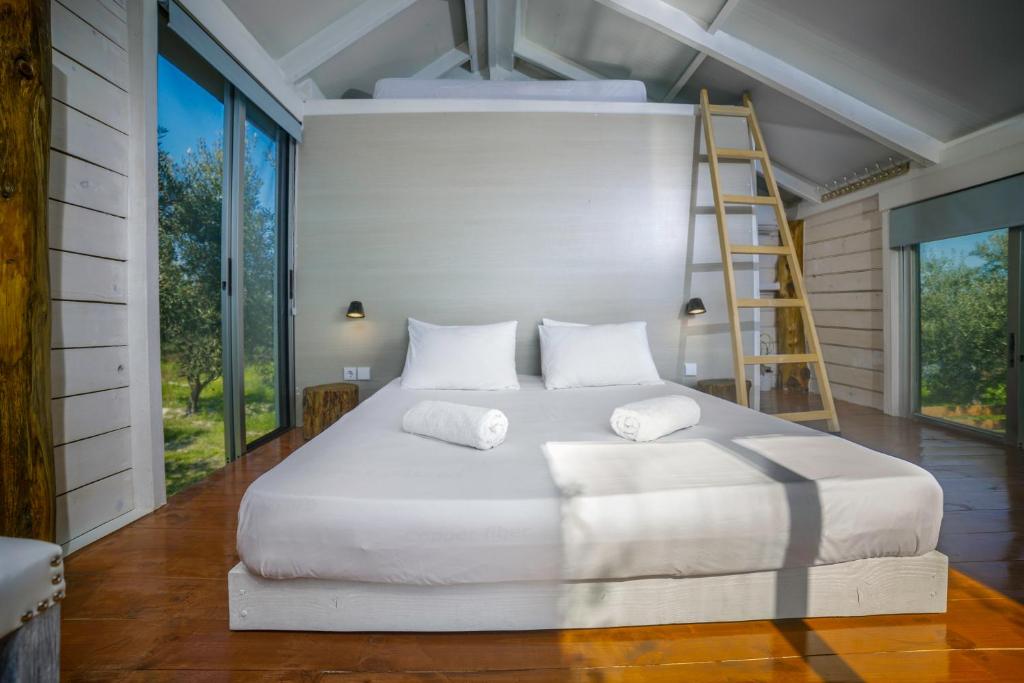un letto bianco in una stanza con una scala di FairyTale a Koukounariá
