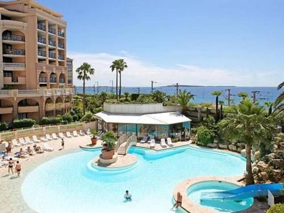 Una gran piscina con gente en un resort. en Appartamento in riva al mare a Cannes, en Cannes
