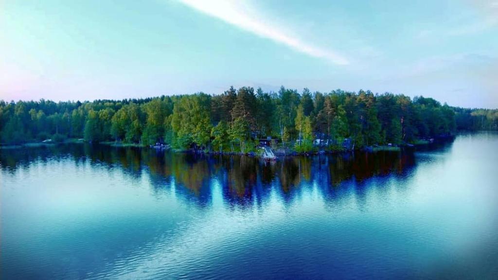 a large body of water with trees in the background at Saaramaa Camping in Kouvola