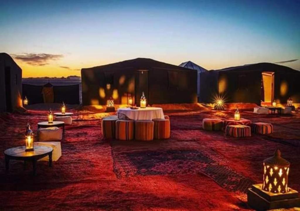 a room with tables and candles in the desert at Bivouac de luxe Mhamid in Mhamid