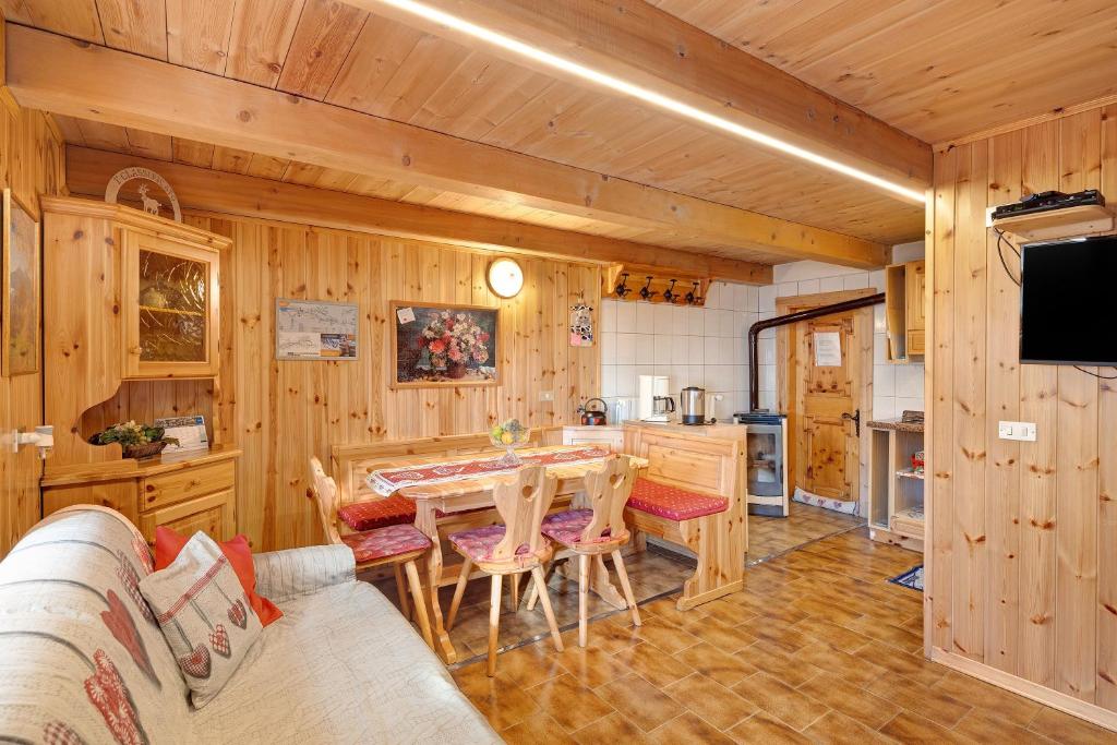 a kitchen with wooden walls and a table and chairs at La Tea di Heidi in Livigno