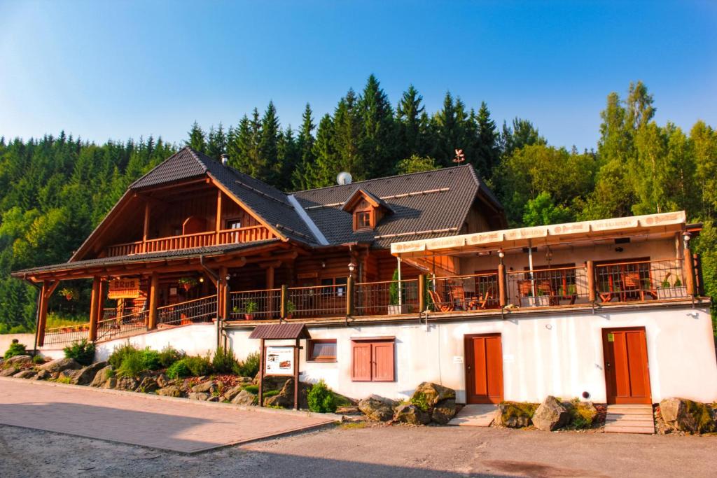 duży drewniany dom z czarnym dachem w obiekcie Srub Karolina w mieście Deštné v Orlických horách