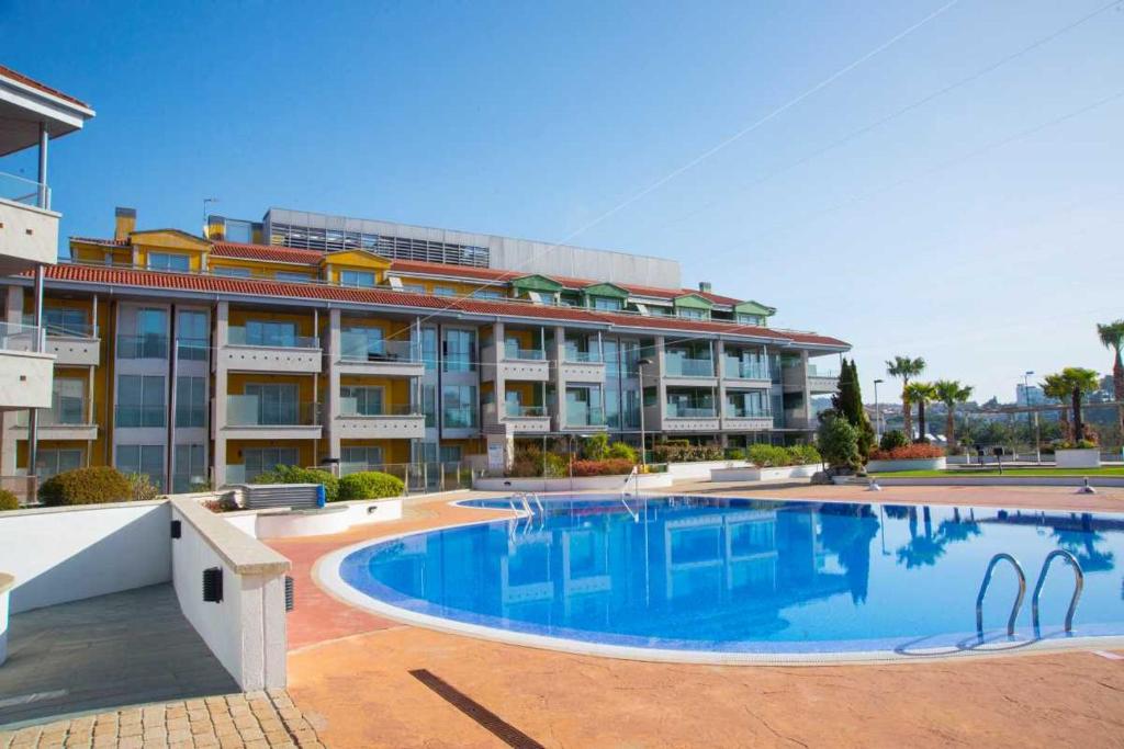 a large apartment building with a large swimming pool at Apartamento Welcome Portonovo Playa in Sanxenxo
