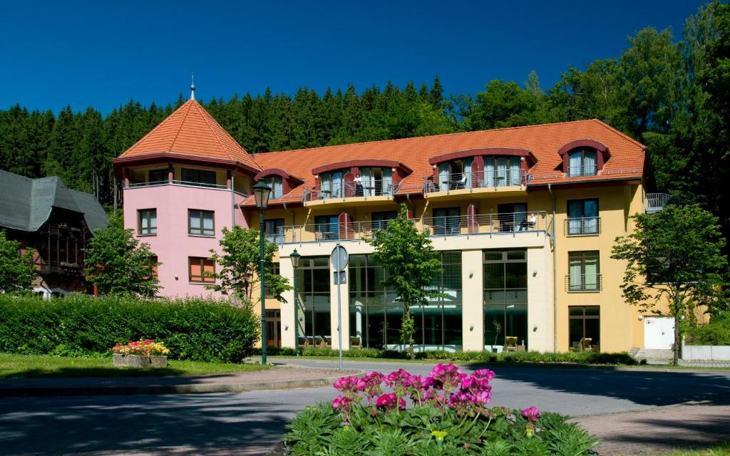 ein großes Gebäude mit rotem Dach in der Unterkunft Hotel Habichtstein in Alexisbad