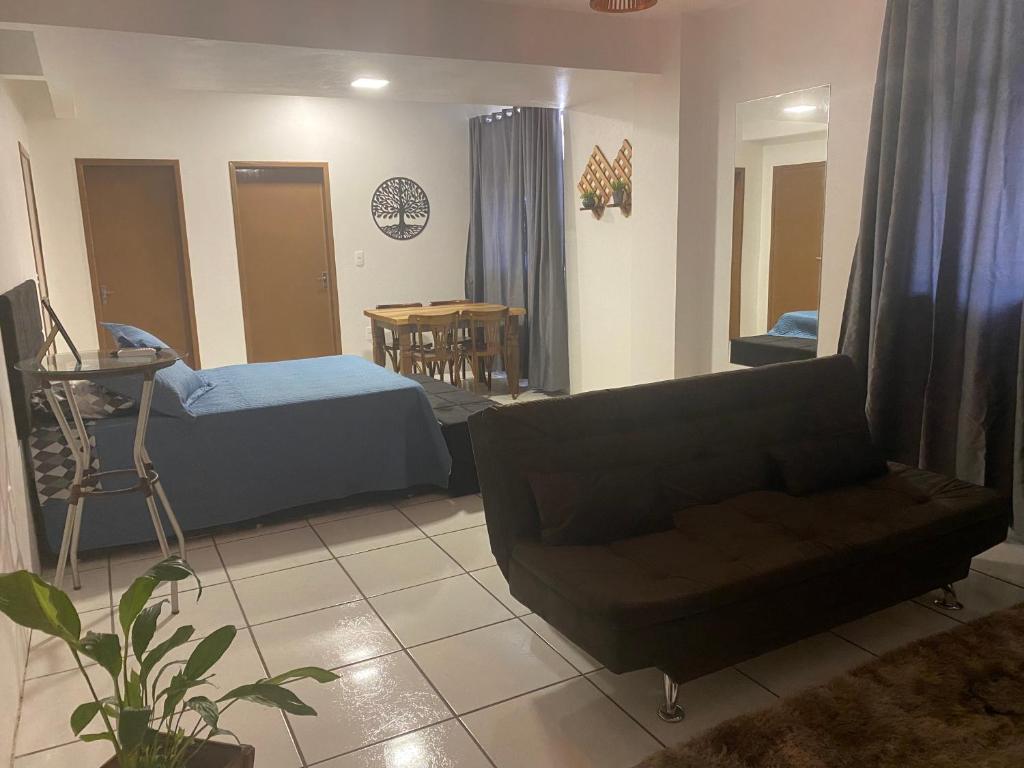 ein Wohnzimmer mit einem Sofa und einem Tisch in der Unterkunft Kitnet Beira Rio in Alfredo Wagner