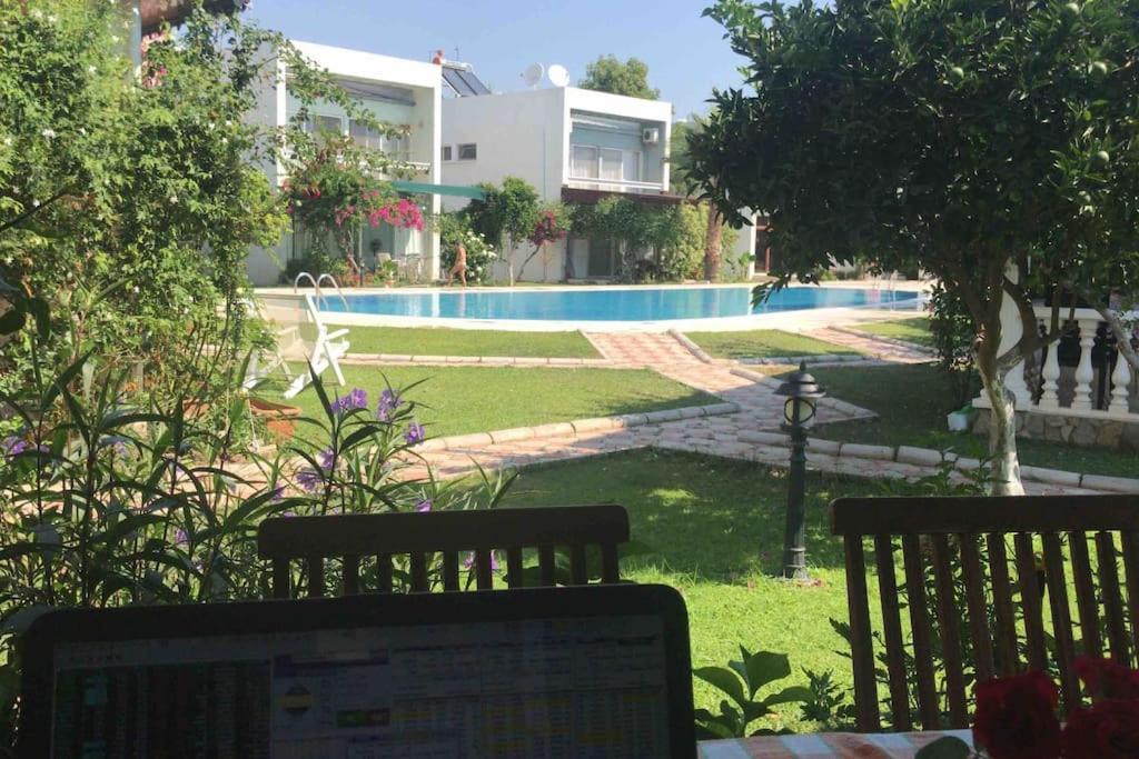 a laptop computer sitting on a bench next to a pool at A Villa For only 90 day and more days in Antalya