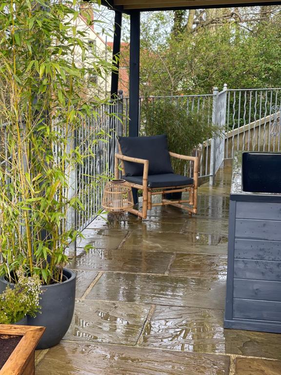 FylingthorpeにあるAshford House 2 bedroom Apartment 'outdoor bathing tub'の雨の中のパティオ(椅子、植物付)