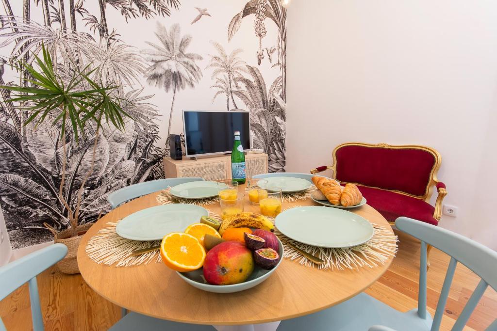 a wooden table with a bowl of fruit on it at Charming Apartment in Private Condominium at Graça in Lisbon