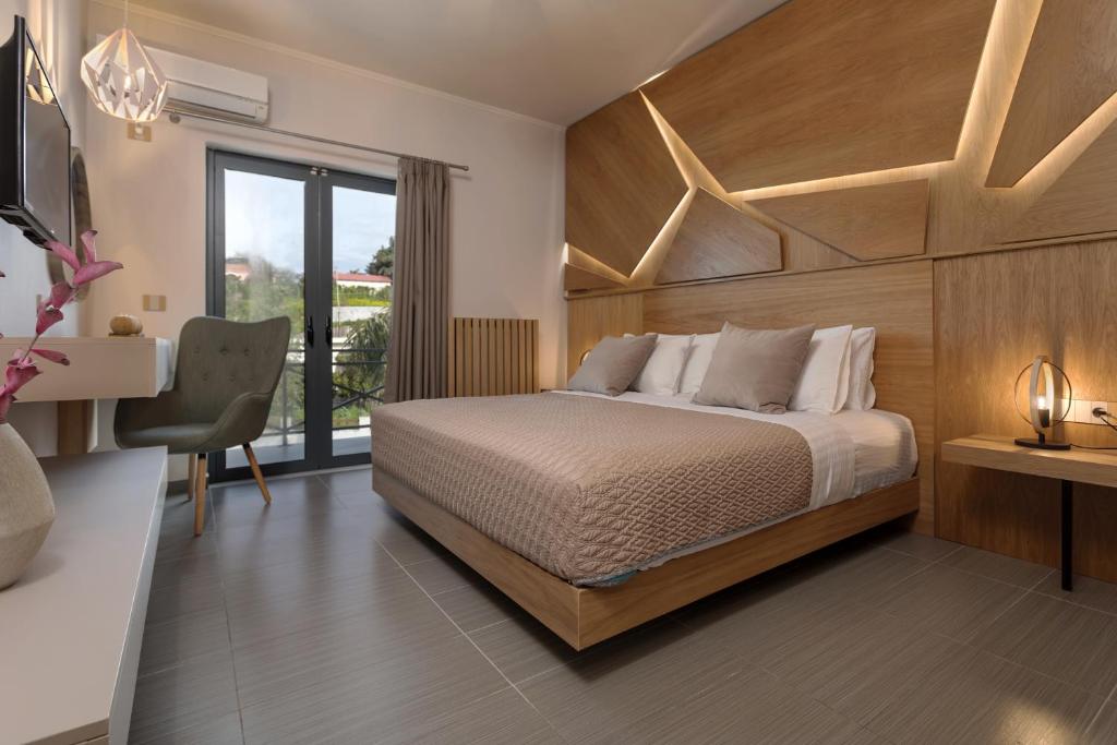 a bedroom with a bed and a desk and a window at Bozikis Villa in Kalpaki