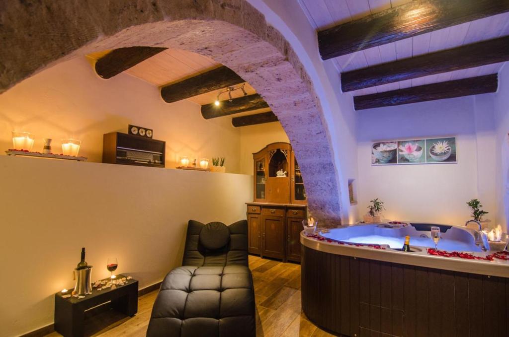 ArkhondikíにあるAngelos House Spa & Hammamのアーチ型の客室で、広いバスルーム(バスタブ付)が備わります。
