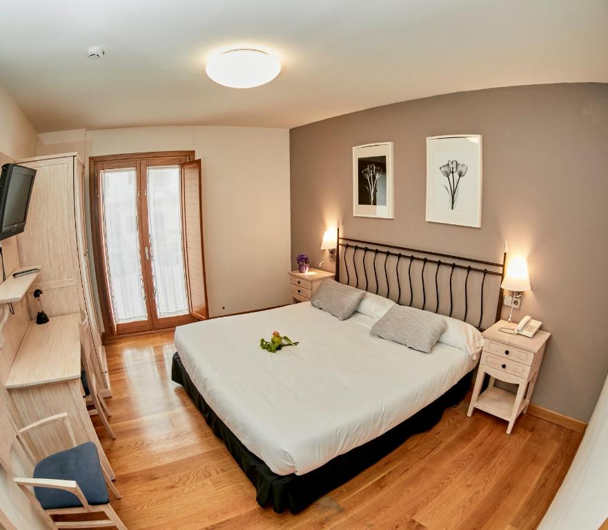 Hotel Casa Azcona في ثيثور مايور: غرفة نوم بها سرير كبير وعليه زهور