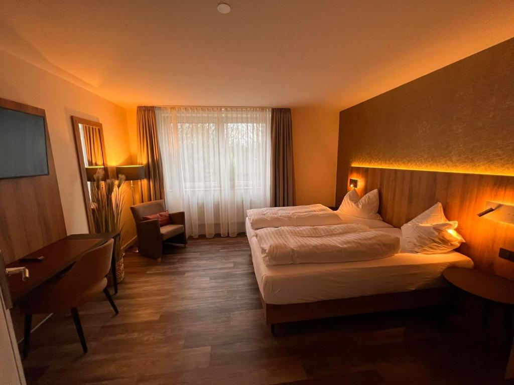 ein Hotelzimmer mit einem großen Bett und einem Fenster in der Unterkunft Hotel-Restaurant Amadeus in Hannover