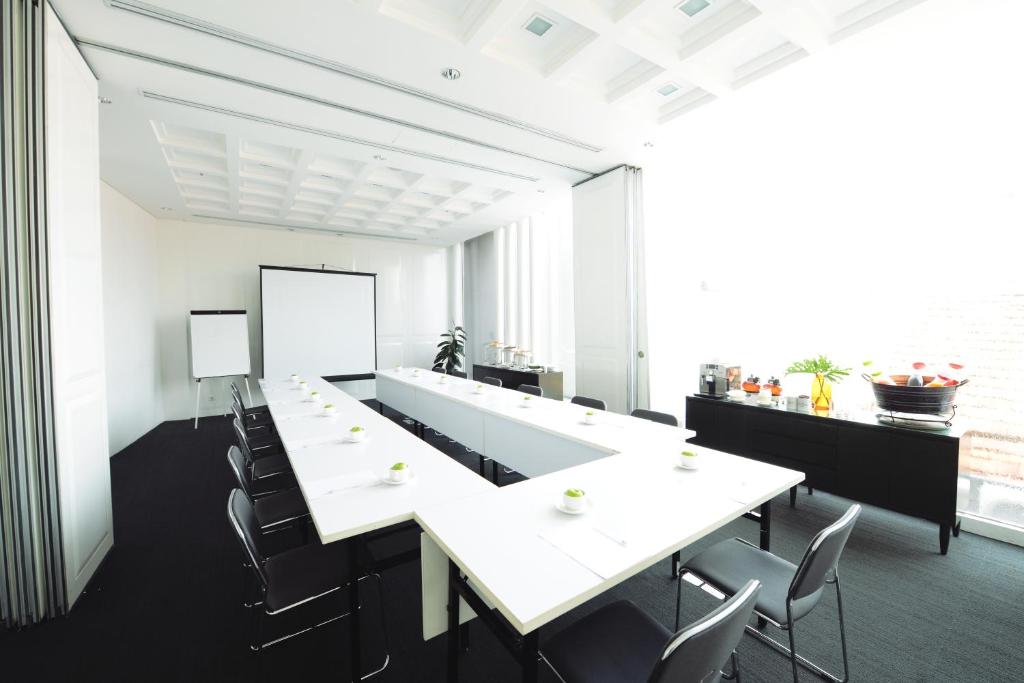 a conference room with a long white table and chairs at Morrissey Hotel in Jakarta