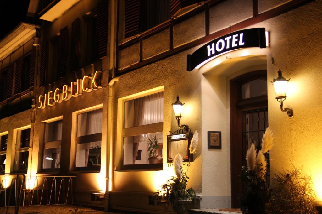 uma placa de hotel no lado de um edifício à noite em Hotel Restaurant Siegblick em Siegburg