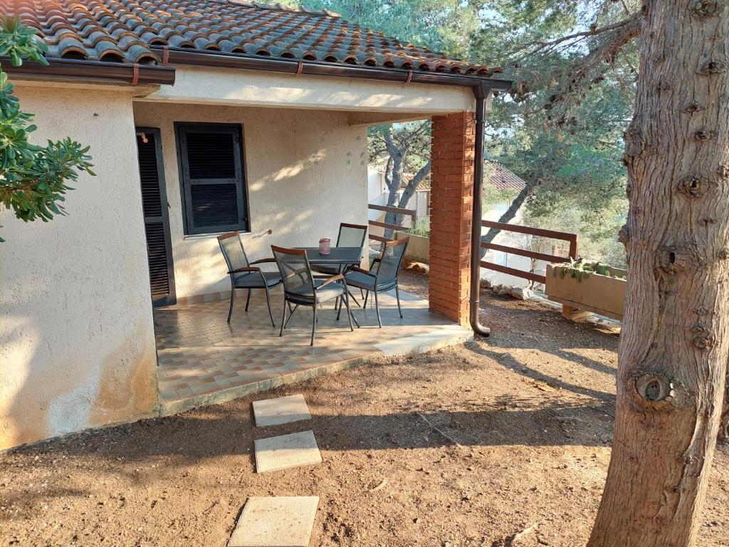 a patio with a table and chairs on a house at Gavza Joy in Cres