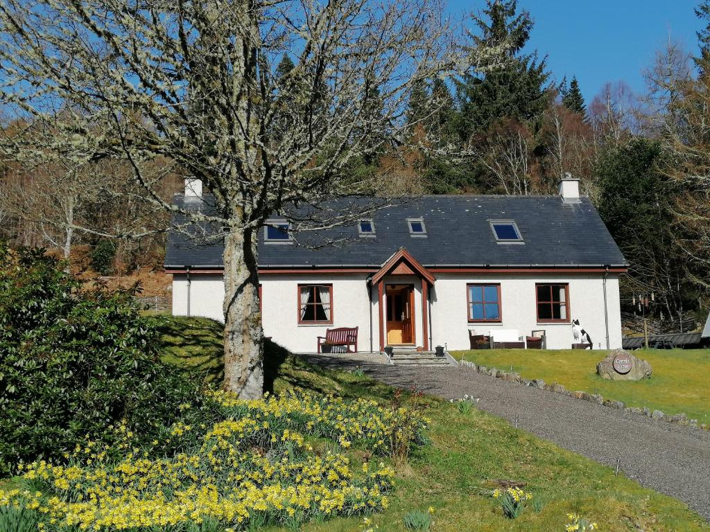 een wit huis met een boom ervoor bij Corrie View in Invergarry