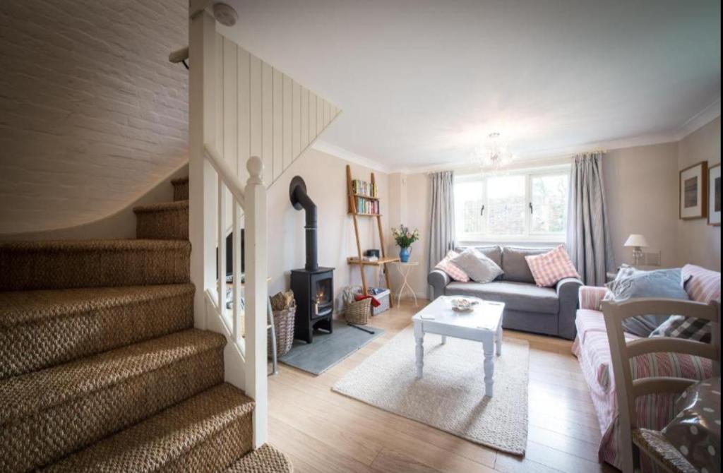 a living room with a couch and a fireplace at Dreamy Suffolk Country Cottage Escape in Aldeby