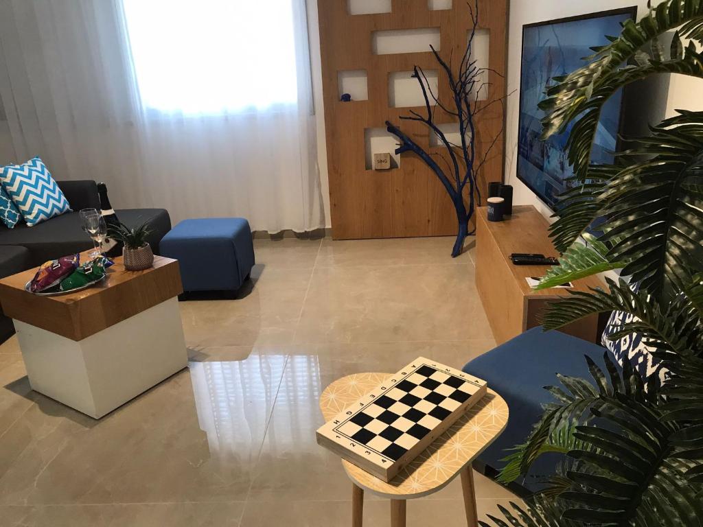 uma sala de estar com um tabuleiro de xadrez num banco em KING of the dead sea by CROWN em Neve Zohar