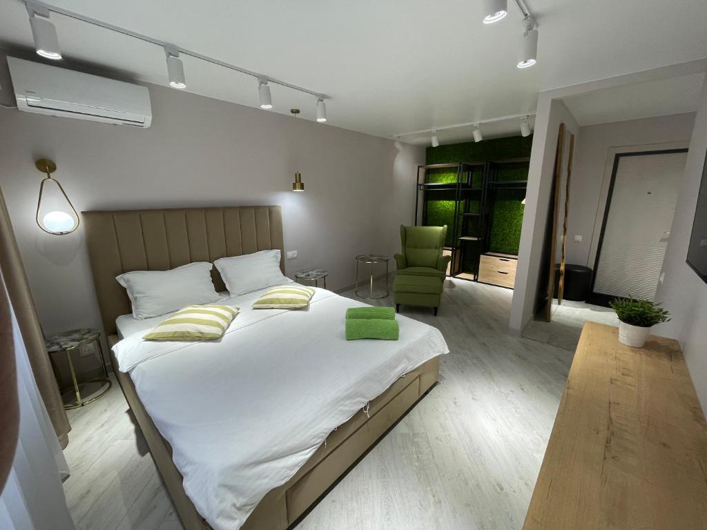 パヴロダルにある“Same as Home apt”M.Zhusupa str. 284/1のベッドルーム(大型ベッド1台、緑の椅子付)